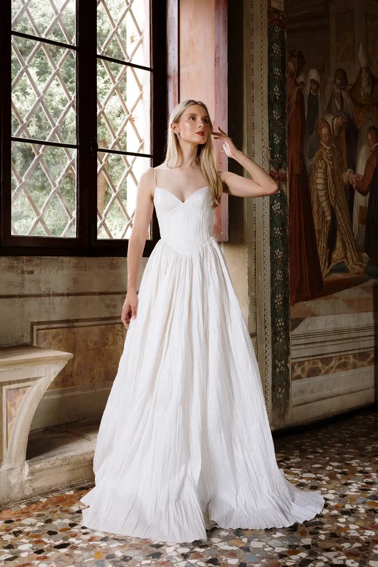 Rhea wedding dress by Aesling Bridal available at Love and Lace Bridal Salon in Orange, CA, featuring crisp pleated taffeta, a plunging V-neckline with delicate 1/2-inch straps, an exaggerated basque waist, and a full gathered circle skirt.