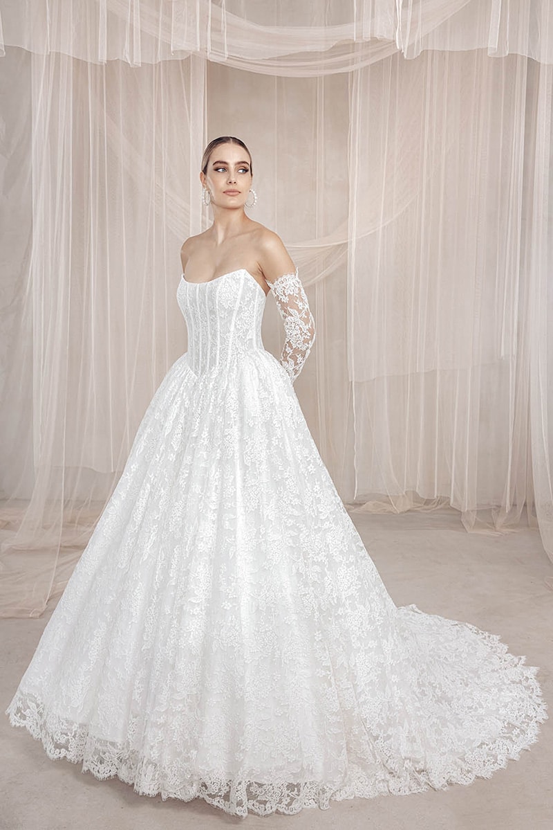 Beth wedding dress by Vagabond Bridal featuring structured scoop neckline, basque waist, romantic Chantilly lace bodice, and luxurious ballgown skirt with lace trim - available at Love and Lace Bridal OC