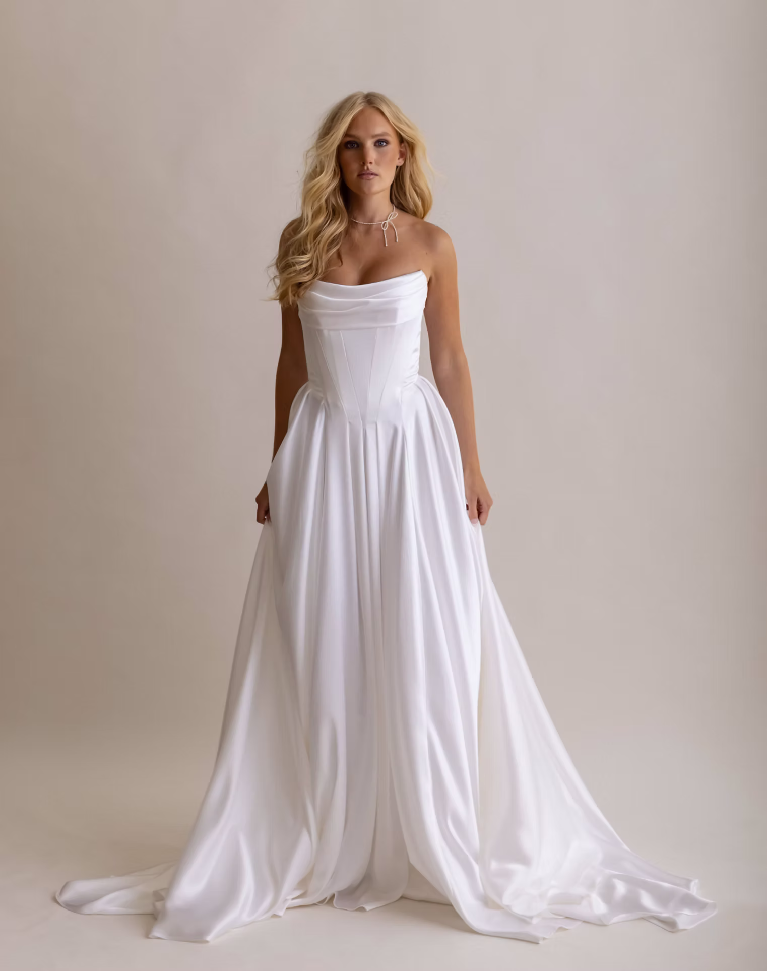 Pisces by Anais Anette Bridal is a wedding gown, available at Love and Lace Bridal Salon in Orange, CA, features a soft cowl neckline, a structured bodice, and flowing skirt.