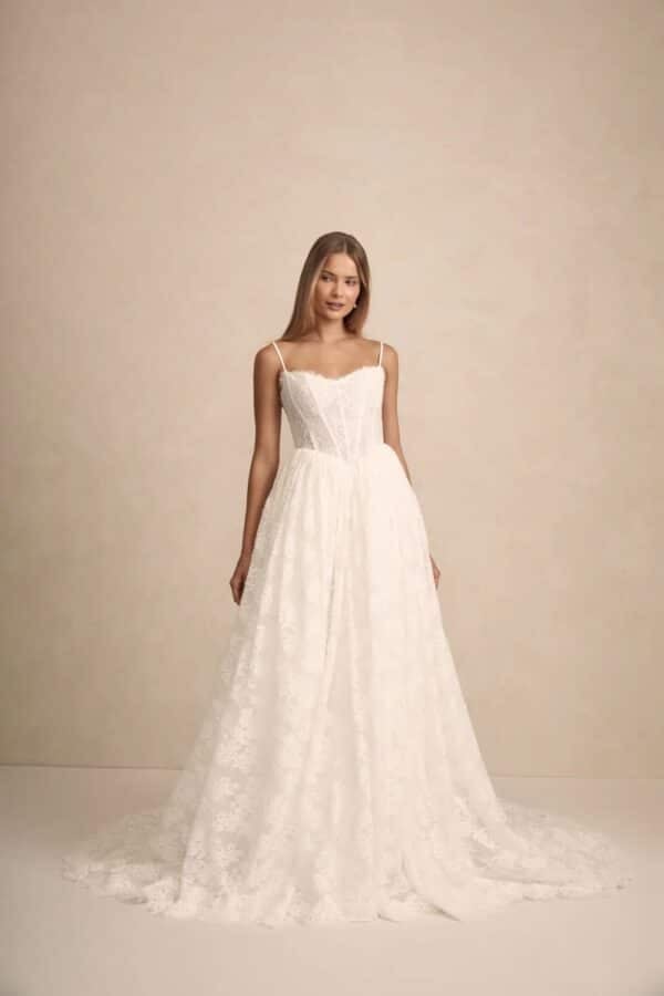 Prim by MWL Bride (formerly Made with Love Bridal) wedding dress in Chantilly lace with a Basque waist, structured bodice, and flowing gathered skirt at Love and Lace Bridal Salon in Orange, CA