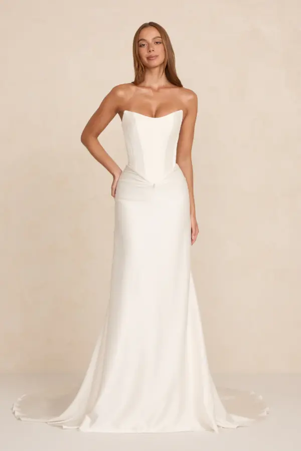 Natalie wedding dress by MWL Bride (formerly Made with Love Bridal) at Love and Lace Bridal Salon in Orange, CA: a strapless crepe satin gown featuring a cinched scooped bodice, front drape with a teardrop pearl detail, and smooth train.