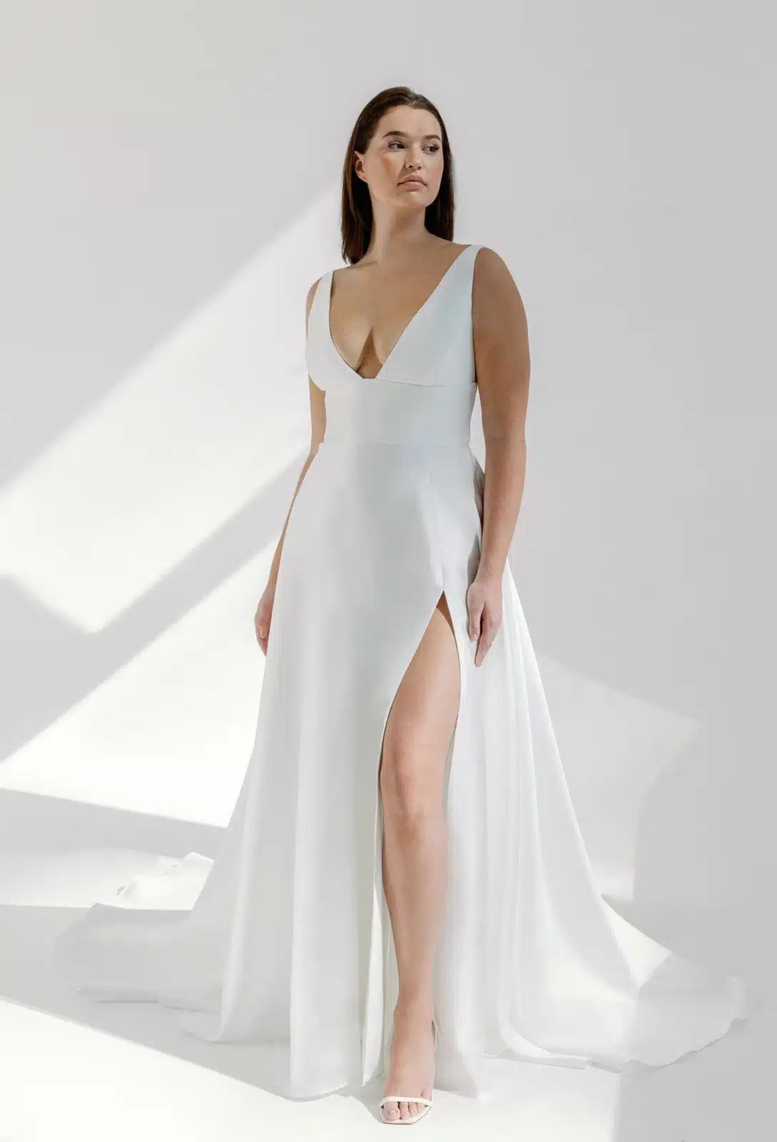 Vivian in Spanish Mikado by Alyssa Kristin is an A-line wedding dress with squared v-neck and high slit, available at Love and Lace Bridal Salon in Orange, CA.