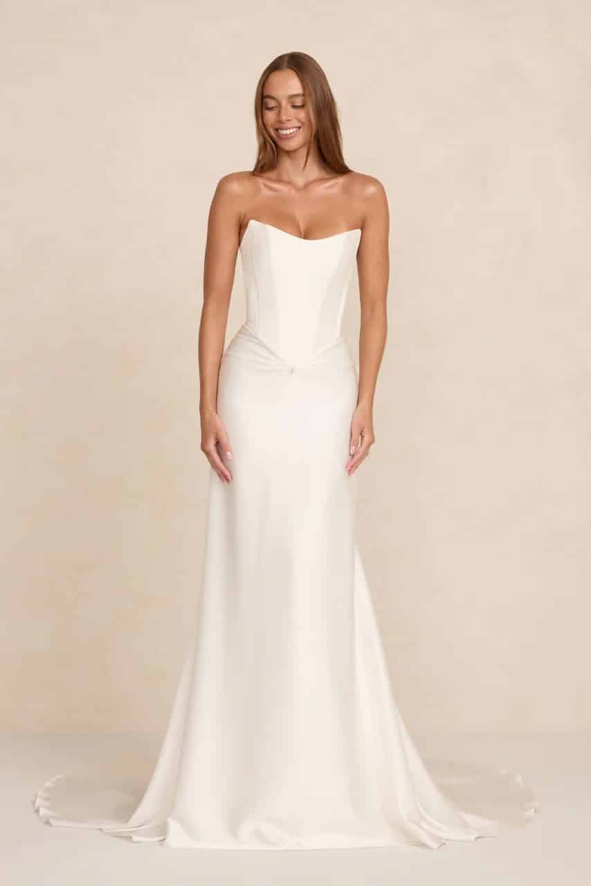 Natalie wedding dress by MWL Bride (formerly Made with Love Bridal) at Love and Lace Bridal Salon in Orange, CA: a strapless crepe satin gown featuring a cinched scooped bodice, front drape with a teardrop pearl detail, and smooth train.