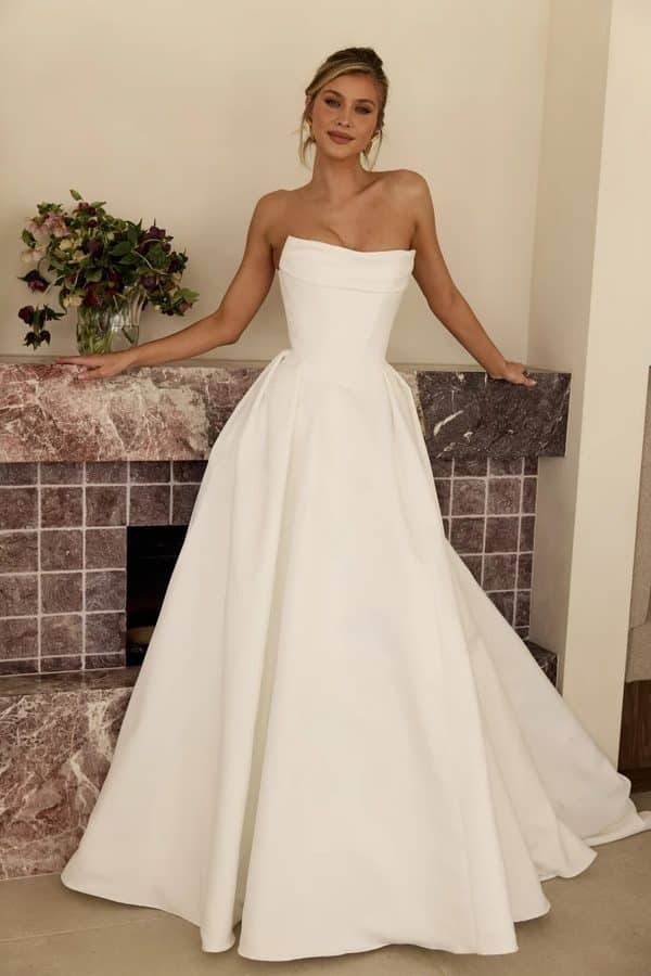 Monroe wedding dress by MWL Bride (Made with Love Bridal) in duchess satin featuring a structured corset bodice, detachable cowl, and romantic skirt at Love and Lace Bridal Salon in Orange, CA.
